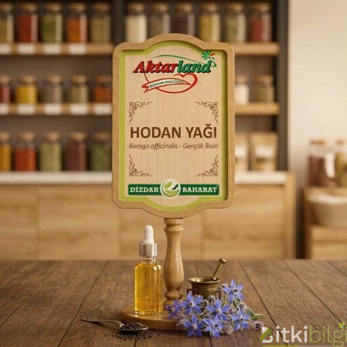 Mavi yıldız şeklinde hodan çiçekleri, siyah hodan tohumları ve yanında koyu renkli cam şişede Hodan Yağı.
