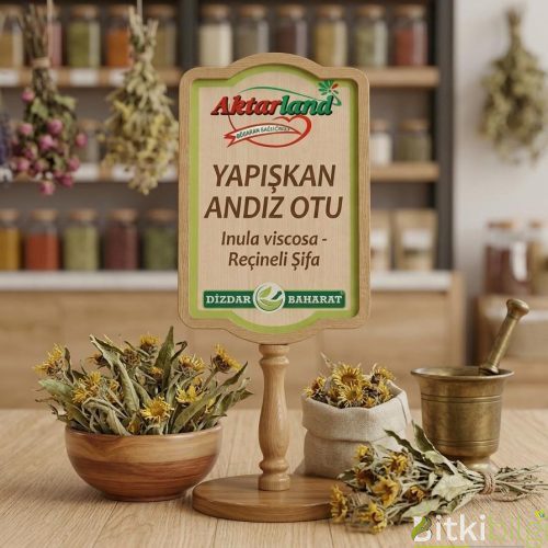 Ahşap bir zemin üzerinde duran taze yapışkan otu yaprakları ve cam şişe içerisinde sıvı bitki çayı.
